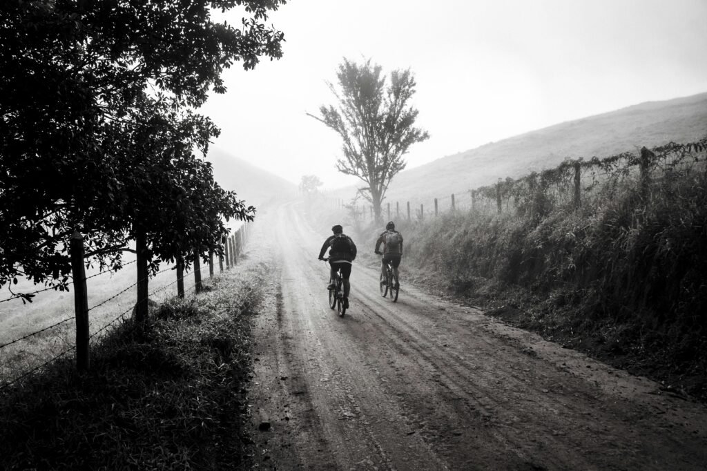 Two cyclists riding together on a misty road in black and white — evoking the quiet uncertainty when cofounder ambitions begin to drift apart