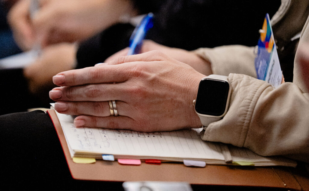 Business professionals with hands together in prayer or meditation during meeting