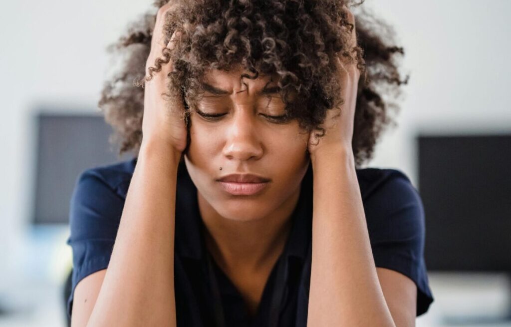 Exhausted cofounder with hands in hair showing signs of overwhelm and burnout