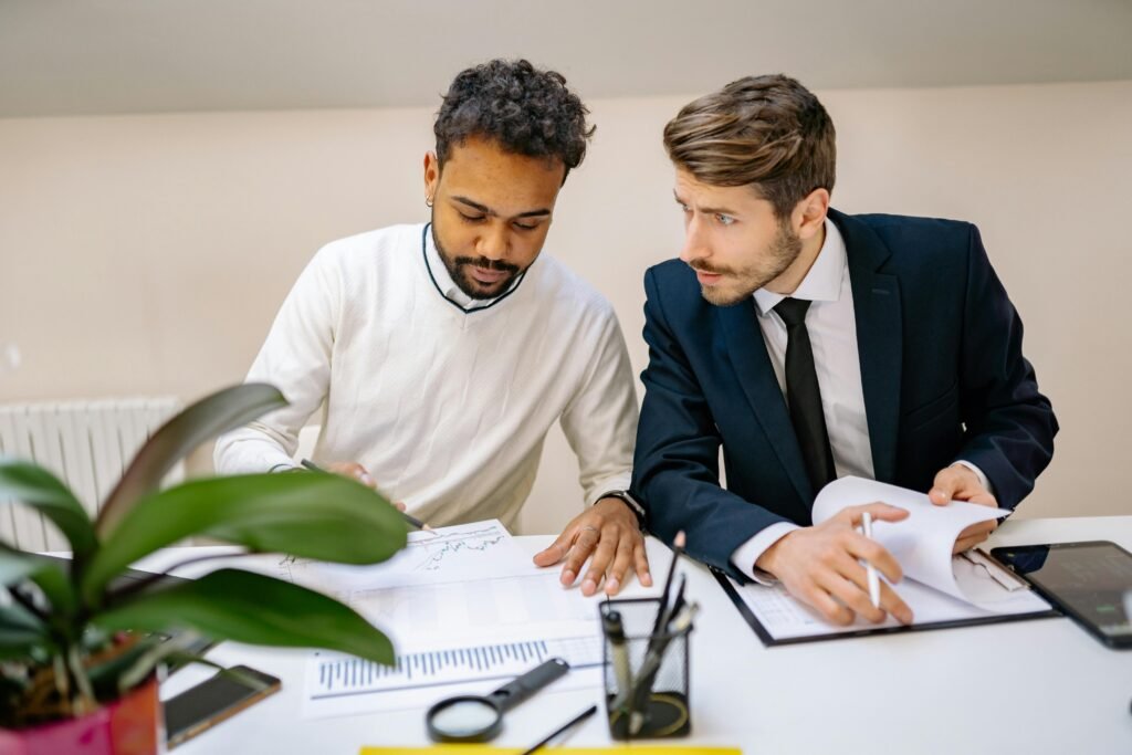 Two co-founders reviewing business strategy documents together — navigating the shift from professional services to productisation