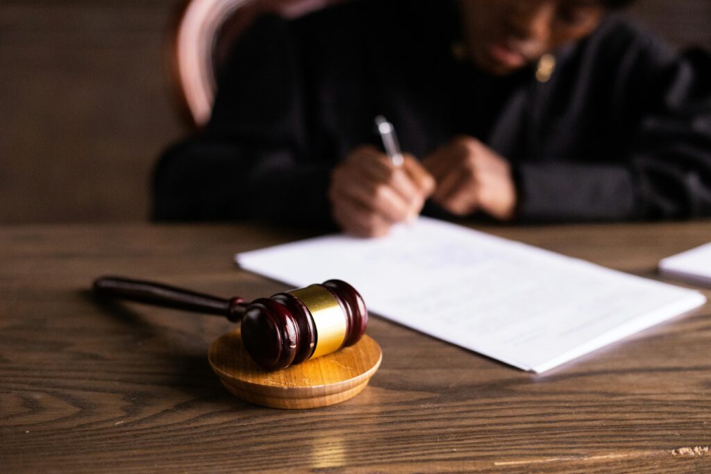 Judge signing legal documents at a courtroom desk with a wooden gavel in the foreground – symbolising private communications becoming legal evidence