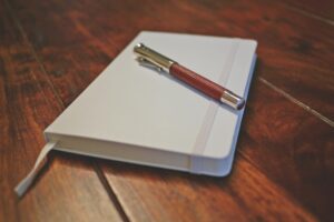 leather notebook and pen on a wooden desk – representing a founder's private journal or diary