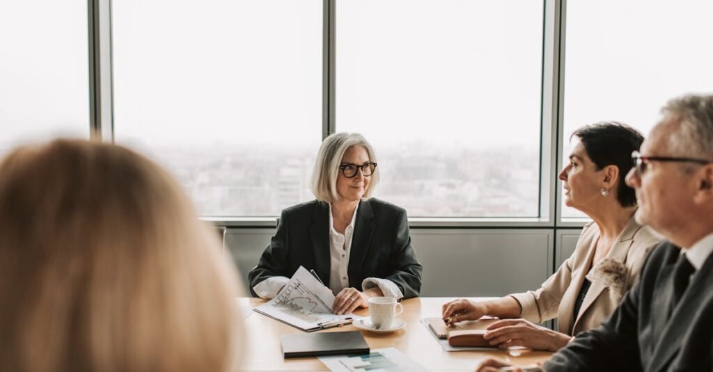 A group of professionals engaged in a business meeting inside a modern office boardroom.
