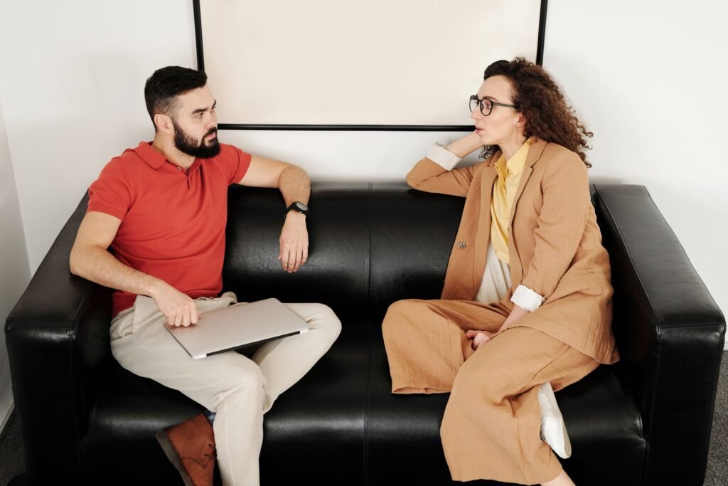 Two business partners having a calm, serious conversation, representing the realignment and renegotiation stage of a cofounder relationship
