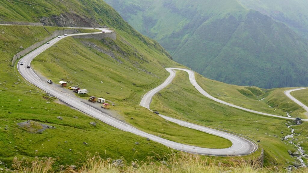Aerial view of a winding mountain road with sharp S-curves through green hills, symbolising the ups and downs cofounders move through together