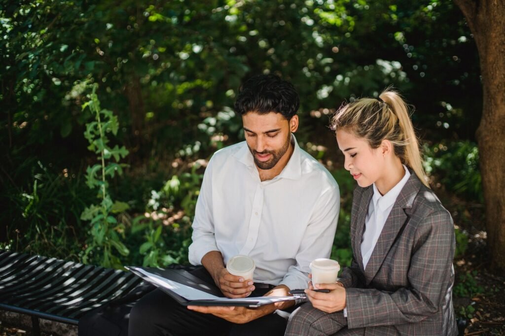 Two co-founders calmly reviewing documents together outdoors, representing constructive dialogue